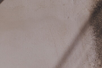 Close-Up View of Textured Wall Surface with Subtle Marks and Shadows in Natural Light Setting
