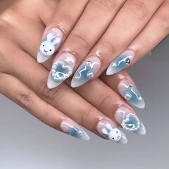 Trendy nail design featuring cute bunny charms, hearts, and dreamy blue accents for a stylish look