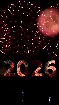 vertical 4K. seamless looping of firework of year 2026 greeting during new year eve countdown celebration, real illuminate fireworks festival in the sky display at night with colorful