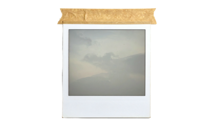 Square photo print depicting cloudy skies taped to black backdrop