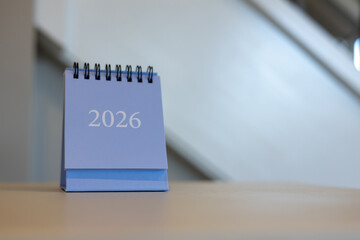 Minimal blue desk calendar displaying year 2026 with neutral background, ideal for time management, planning, corporate visuals, and modern office content.