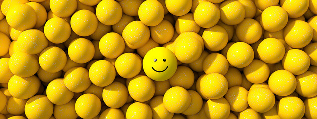 A top view of a sea of yellow balls with one featuring a hidden smiley face