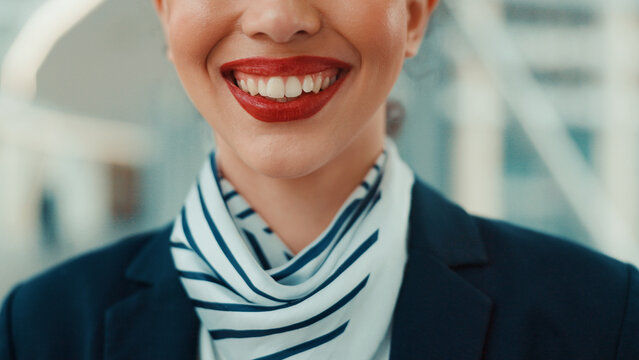 Flight attendant, mouth and smile in airport for travel, journey and transport professional for service. Closeup, happy woman and air hostess for international airline, hospitality and career pride