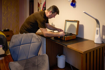 Middle-aged man relaxes by listening to music at home