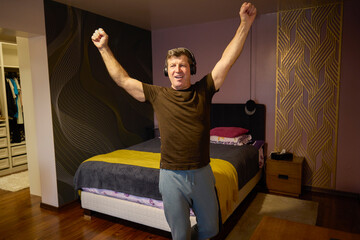 Middle-aged man relaxes by listening to music at home
