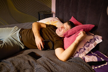 Middle-aged man relaxes by listening to music at home