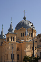 Obraz premium Close-up of a stunning historic Orthodox church, featuring a prominent blue-grey dome, golden cross, and decorative turrets against a clear blue sky