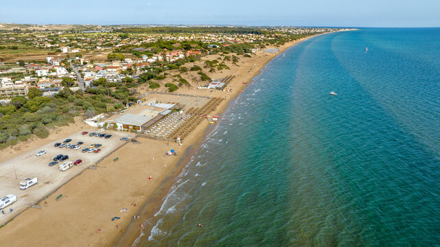 Aerial view of a sandy beach overlooking the Mediterranean Sea. This is the beach of Santa Maria del Focallo, a small tourist and coastal town in the municipality of Ispica, in Sicily, Italy.