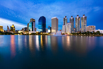 Beautiful view of Bangkok's lake at dusk (blue hour) in Benchakitti Park. Bangkok cityscape at sunset at Benjakitti Park.