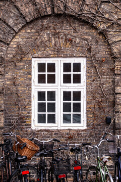 Brick architecture facade with window detail and bicycles in Copenhagen emphasizing texture and contrast within a clearly structured exterior view intended for broad visual communication