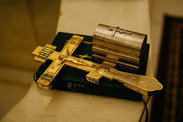 Orthodox golden crucifix lies on the Bible in the church
