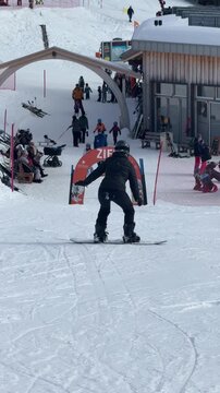 newbie Snowboarder riding down ski slope in winter resort