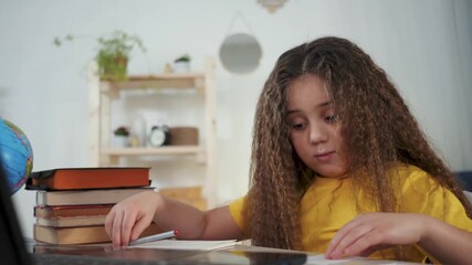 child studies on laptop with stack of book and globe on desk while girl does online learning and homework showing focused study and curious expression in home learning environment calm focus - Powered by Adobe