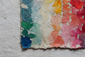 Bright watercolor palette with vibrant colors on textured paper surface