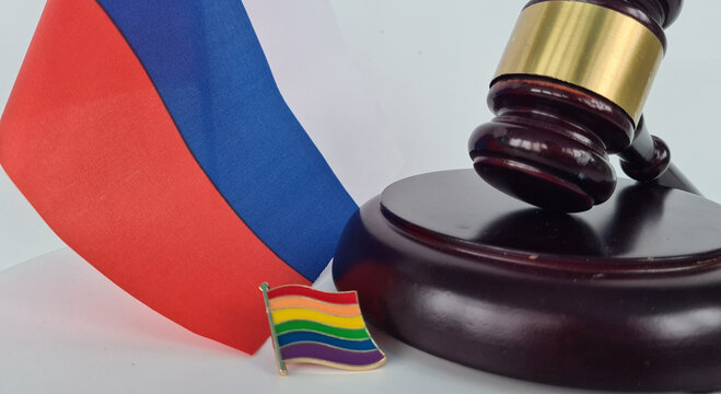 Russian Flag, Gavel, and Rainbow Pride Flag on White Background
