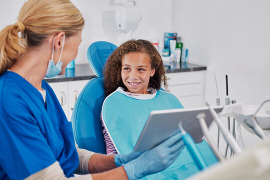 Dentist showing teeth x-ray on tablet to child