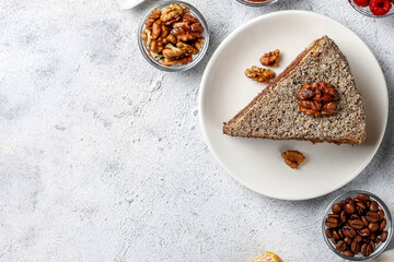 Slice of Chocolate Cake with Walnut Topping on a White Plate with Coffee Beans and Nuts