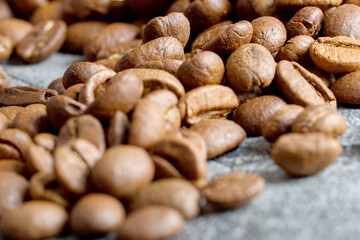 Macro Shot of Freshly Roasted Coffee Beans Piled on a Textured Grey Stone Surface