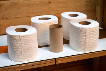 toilet paper rolls on a wooden shelf