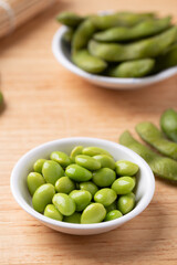 Boiled Edamame beans (Japanese soybeans) in a bowl on wooden background