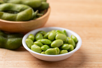 Boiled Edamame beans (Japanese soybeans) in a bowl on wooden background