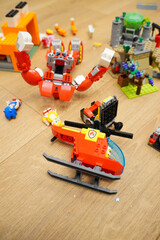 Obraz premium Colorful toy helicopter and robot with other building blocks on a wooden floor