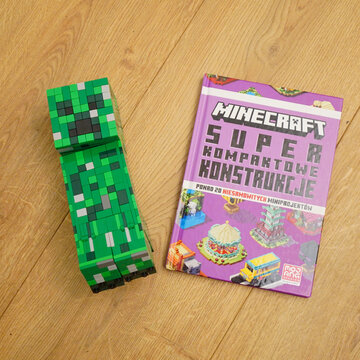 Minecraft Creeper figure and book on a wooden surface