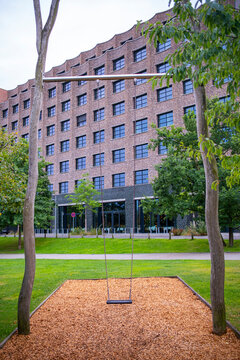 Modern architecture and park design combining building, swing, trees, greenery and urban structure in HafenCity Hamburg Germany for contemporary city visuals