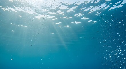 Vibrant underwater scene with glistening sunbeams penetrating the pristine ocean surface and rising air bubbles