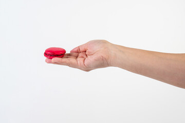 Red macarons in hand on white background