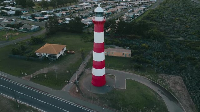 Cinematic aerial footage showing a slow pan away fro the Point Moore Lighthouse, slowly revealing more of Geraldton town and the beach where the waves of the Indian Ocean crash upon.