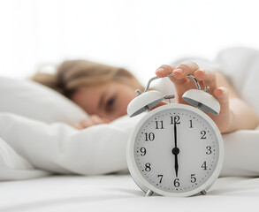 A hand reaches toward ringing alarm clock, interrupting peaceful sleep.