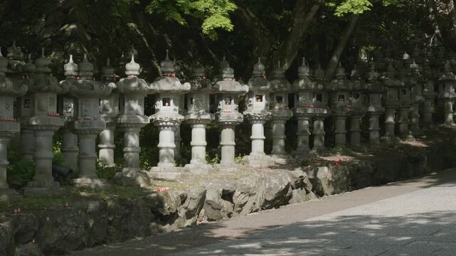 Stone statues with red daruma dolls in Katsuoji Temple, Osaka, Japan.