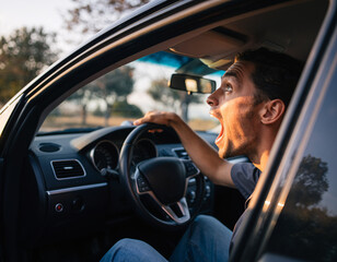 Shocked man reacting dramatically while sitting in car during daylight