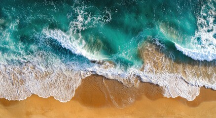 An aerial view shows powerful turquoise ocean waves crashing onto a golden sandy beach