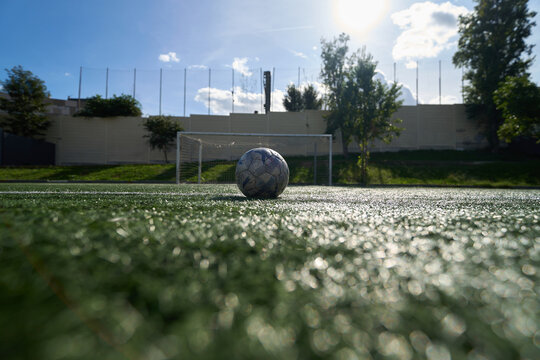 Old soccer ball resting on artificial grass field - Powered by Adobe