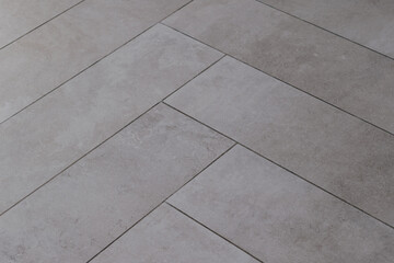 Grey rectangular tile texture in herringbone pattern imitating natural stone