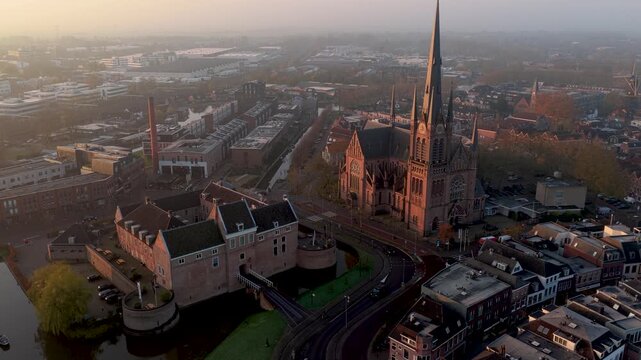 Aerial view of the Kasteel Woerden and Sint-Bonaventurakerk, with warm sunlight casting shadows across the buildings, Woerden, Utrecht, Netherlands.