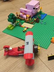 Obraz premium Red Biplane Lego and Minecraft Pig House on a Green Baseplate