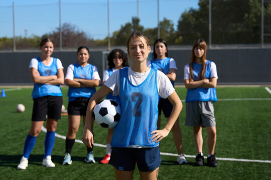 Confident female soccer player with her team - Powered by Adobe