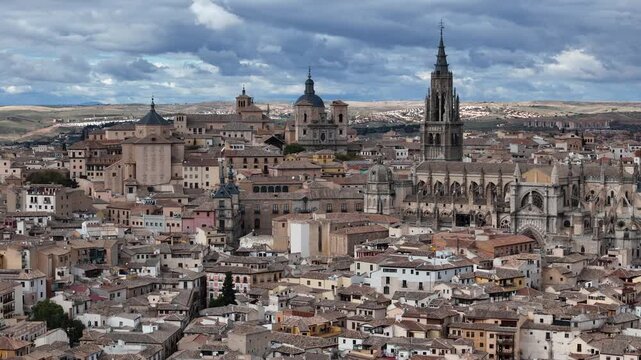 Aerial view of the Toledo Cathedral and cityscape, with its intricate gothic architecture standing out against the warm tones of the surrounding buildings, Toledo, Castile-La Mancha, Spain.