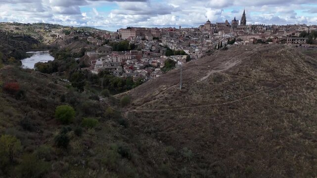 Aerial view of Toledo, showcasing the city's architecture along the Tagus River, where the buildings contrast with the natural landscape, Toledo, Castile-La Mancha, Spain.