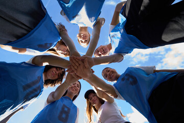 Female soccer team stacking hands for unity and teamwork