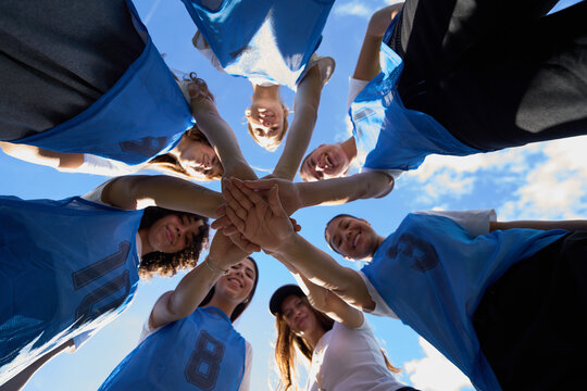Female soccer team stacking hands for unity and teamwork - Powered by Adobe