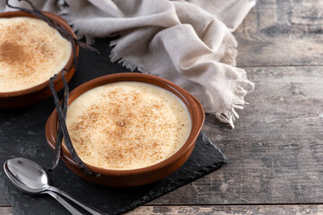 Creamy homemade Spanish custard served in a bowl on wooden table. Copy space