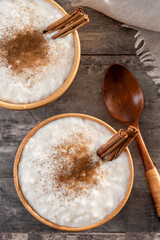 Rice pudding with cinnamon in wooden bowl. Top view