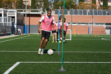 Young men training soccer agility with poles