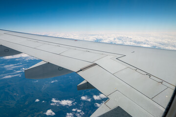 Fototapeta premium view of the earth and clouds from the window of a flying airplane