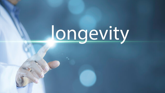 Medical longevity concept showing a doctor’s hand touching a glowing virtual interface with the word “longevity” on a blue technology background. Ideal for healthcare innovation, wellness,