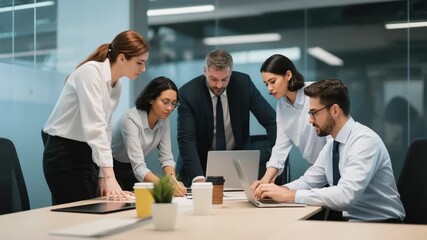 Group of diverse business professionals having a meeting around a table in a contemporary office, discussing strategy and working on a laptop together. Teamwork and collaboration concept. - Powered by Adobe